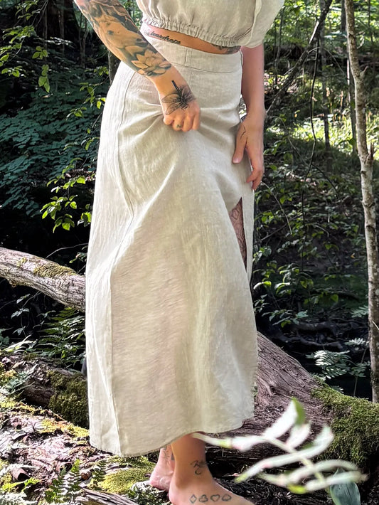 model wear best high waisted linen skirts in Australia. Made from 100% pure French linen, our natural flax skirts feature a stylish thigh slit for breathable comfort and effortless elegance.