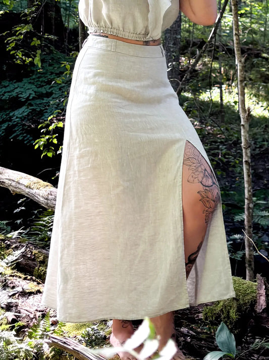 model wear best high waisted linen skirts in Australia. Made from 100% pure French linen, our natural flax skirts feature a stylish thigh slit for breathable comfort and effortless elegance.