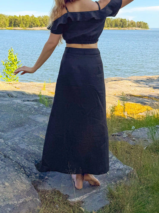 model wear best high waisted linen skirts in Australia. Made from 100% pure French linen, our black skirts feature a stylish thigh slit for breathable comfort and effortless elegance.